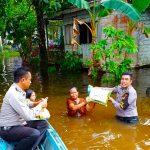 Berikan Bantuan Sembako, Anggota Polsek Tempunak Ini Rela Arungi Banjir